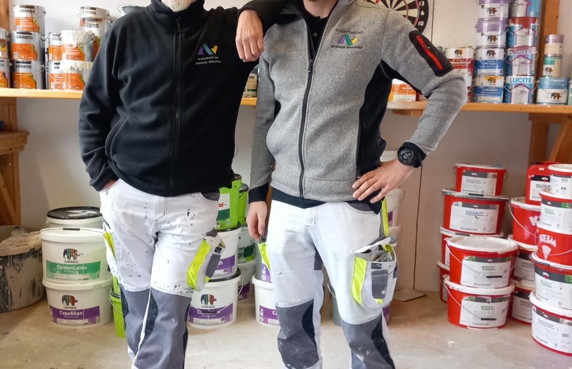 Zwei Maler stehen nebeneinander mit Arm auf Schulter des anderen