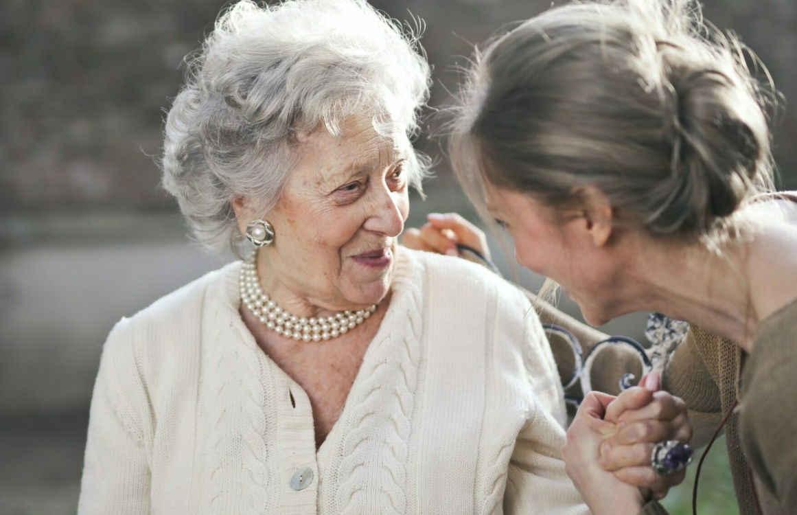Seniorin unterhält sich mit einer jüngeren Frau