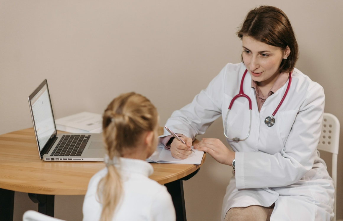 Ärztin mit Kind bei einer Untersuchung im Gespräch