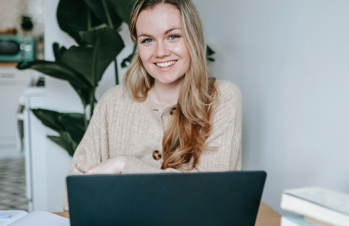 Studentin sitzt vor einem Laptop an ihrem Arbeitsplatz